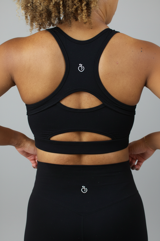Black sports bra with cut-out design on a plain background