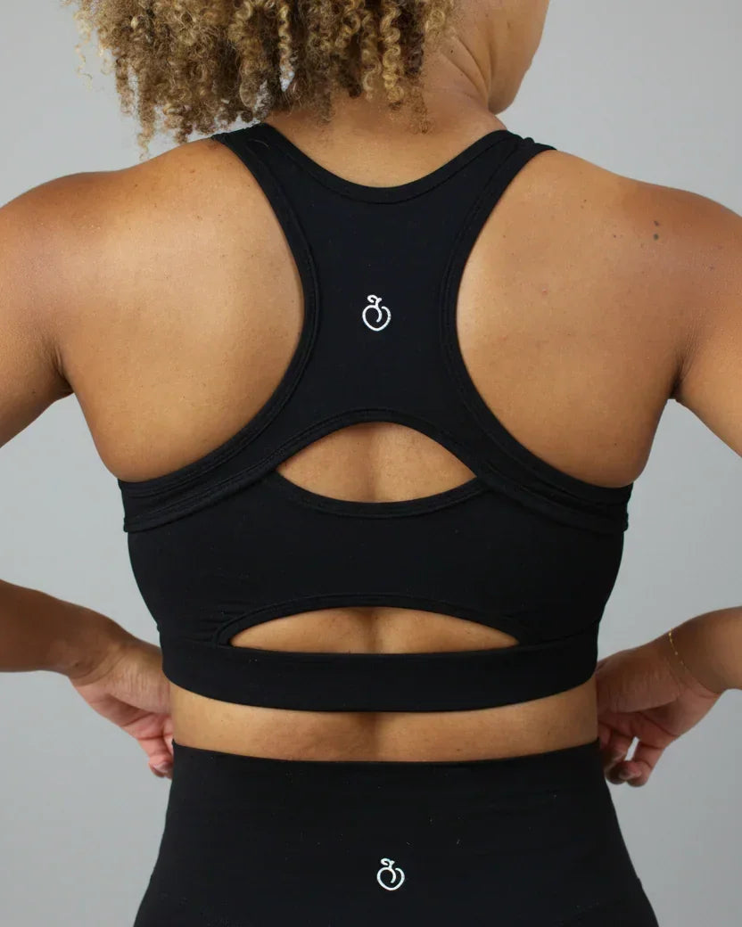 Black sports bra with cut-out design on a plain background