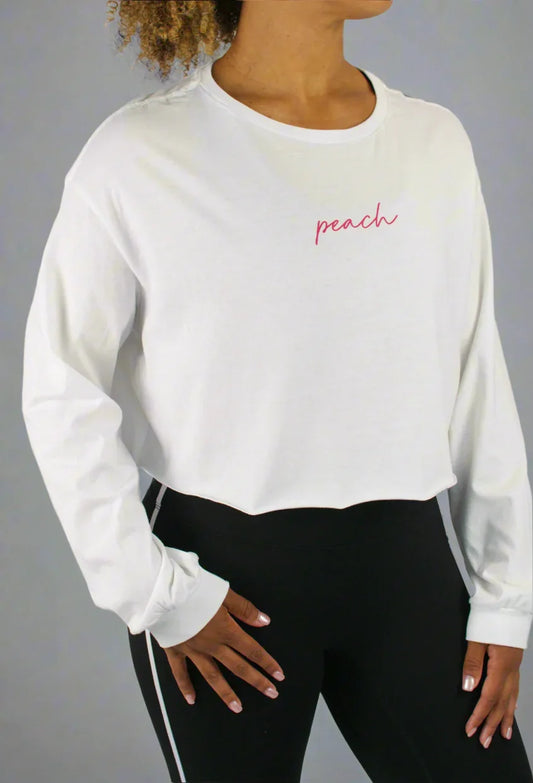 Person wearing a white sweatshirt with 'peach' text and black leggings on a gray background