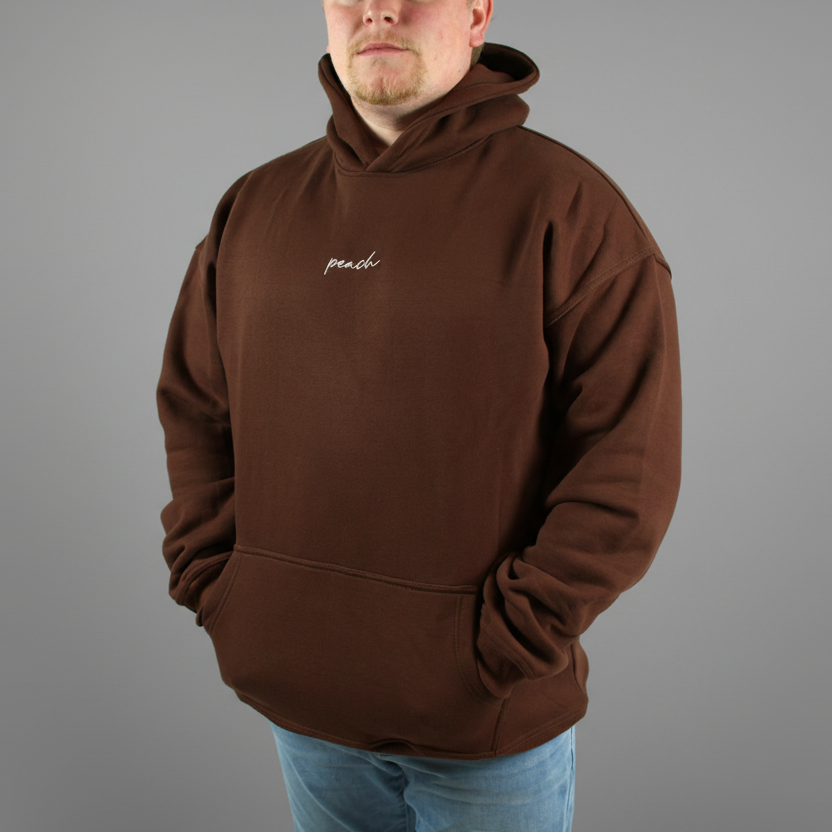 Person wearing a brown hoodie with 'peach' logo on a white background