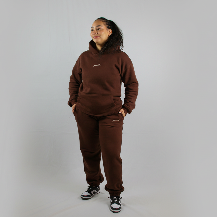 Person wearing a brown tracksuit on a white background