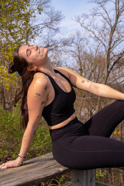 Woman in black athletic wear sitting on a porch