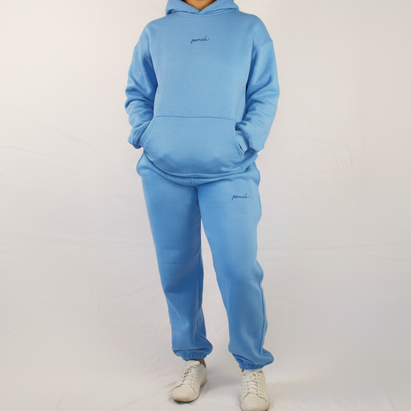 Person wearing a blue tracksuit with 'paul' branding on a white background