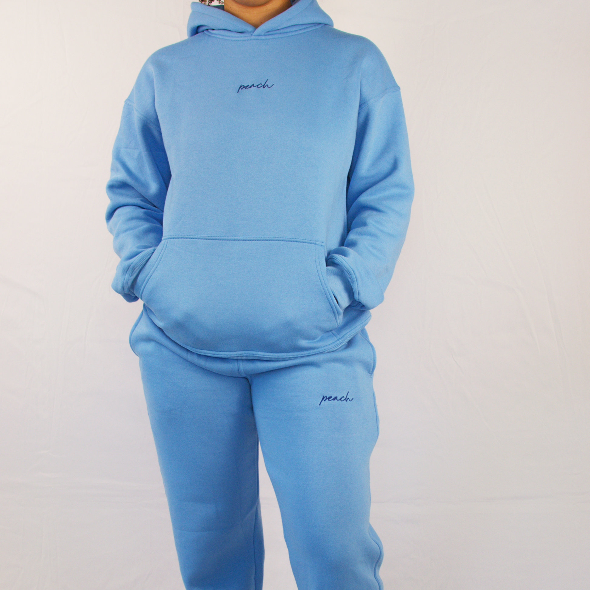 Person wearing a blue tracksuit with 'paul' branding on a white background