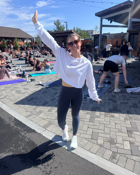 Woman in Peach Active athletic wear smiling outdoors at a group fitness event, sunny day