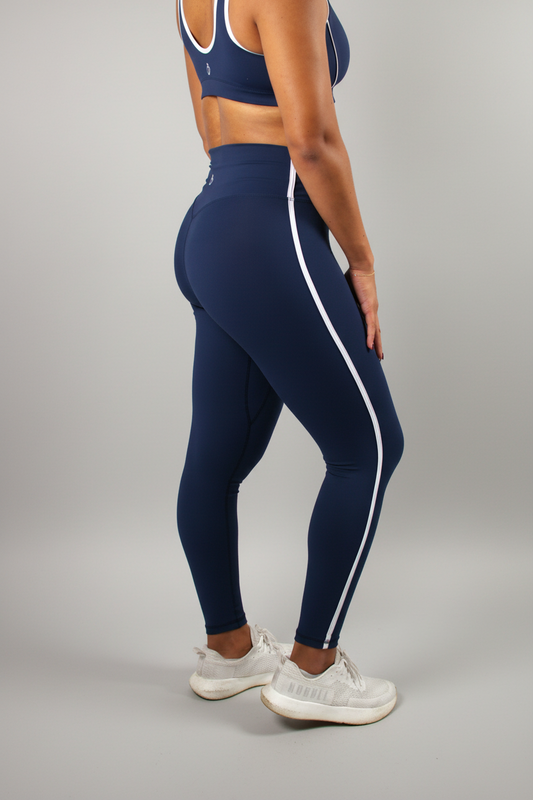 Person wearing navy leggings with white stripes on a white background