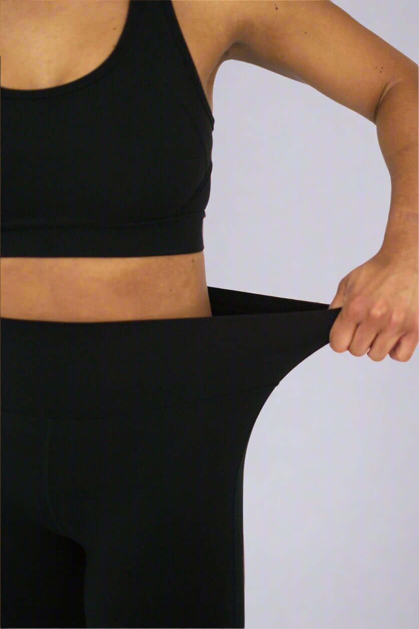 Detailed view showing stretch of high waisted black leggings